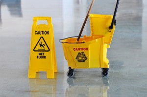 Mop bucket and caution sign on wet floor